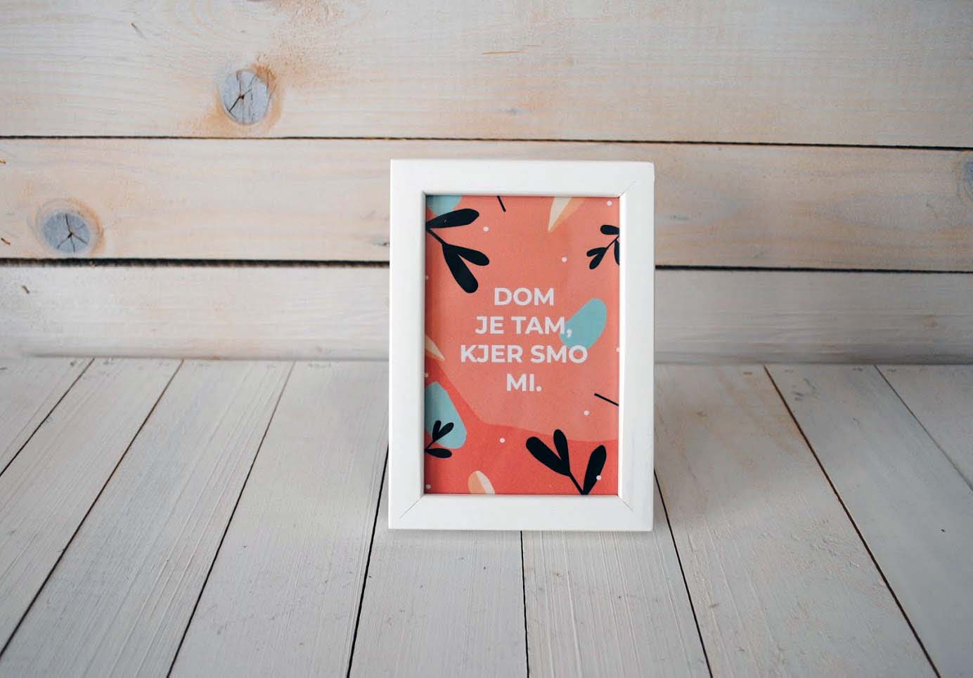 Roza plakat z napisom "Dom je tam, kjer smo mi." v belem okvirju