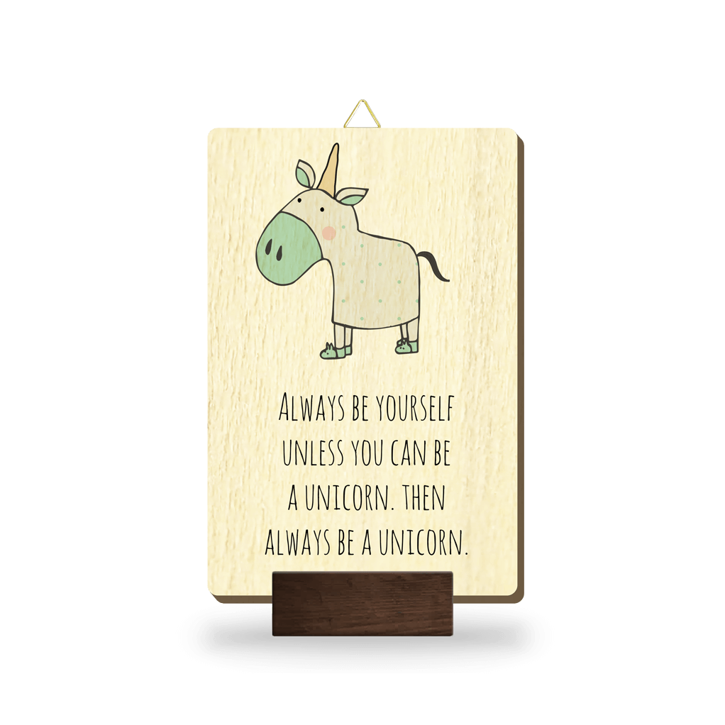 Lesena slika z napisom "Always be yourself unless you can be a unicorn. Then always be a unicorn." in ilustracijo zelenega osla