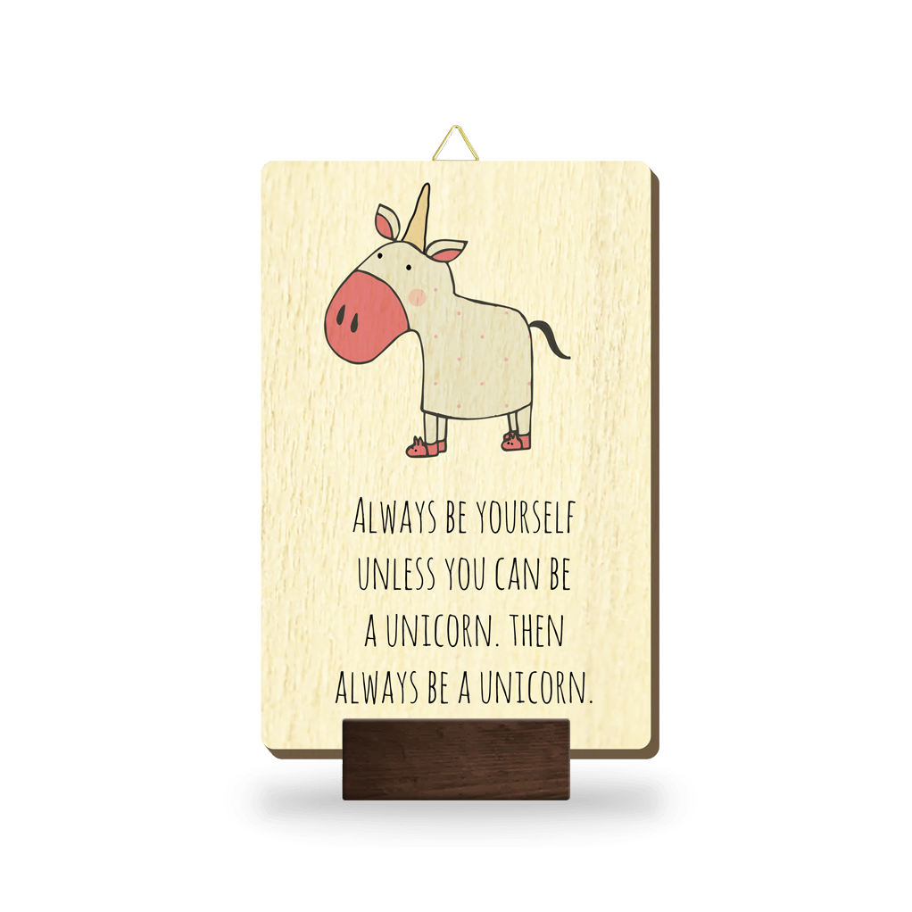 Lesena slika z napisom "Always be yourself unless you can be a unicorn. Then always be a unicorn." in ilustracijo roza osla
