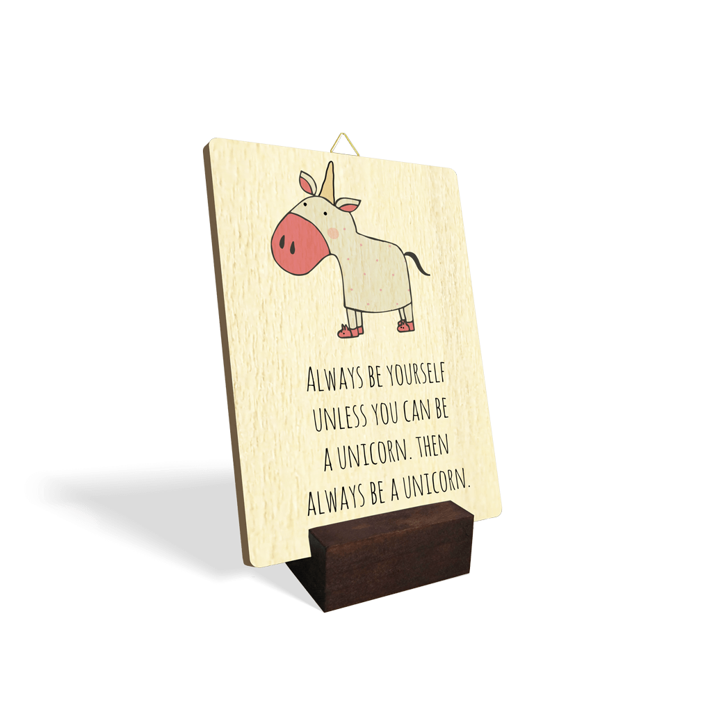 Lesena slika z napisom "Always be yourself unless you can be a unicorn. Then always be a unicorn." in ilustracijo roza osla